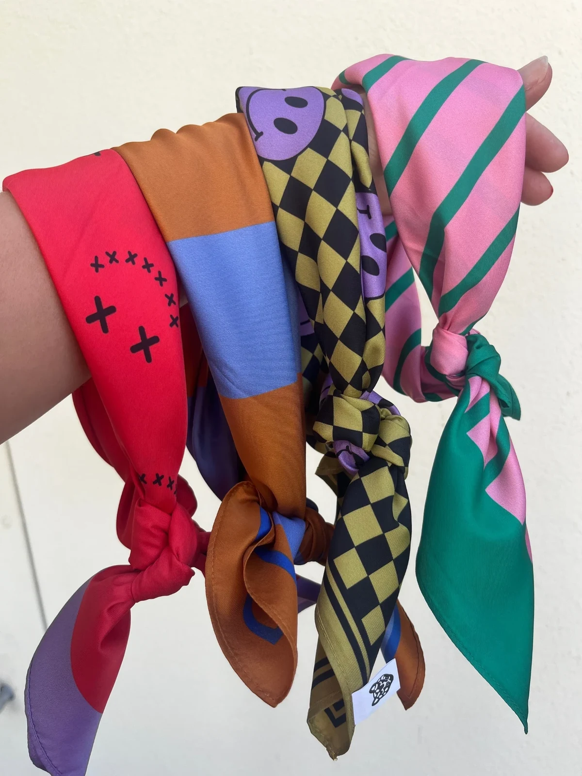 Hand met gekleurde sjaaltjes van Colori Ribelle